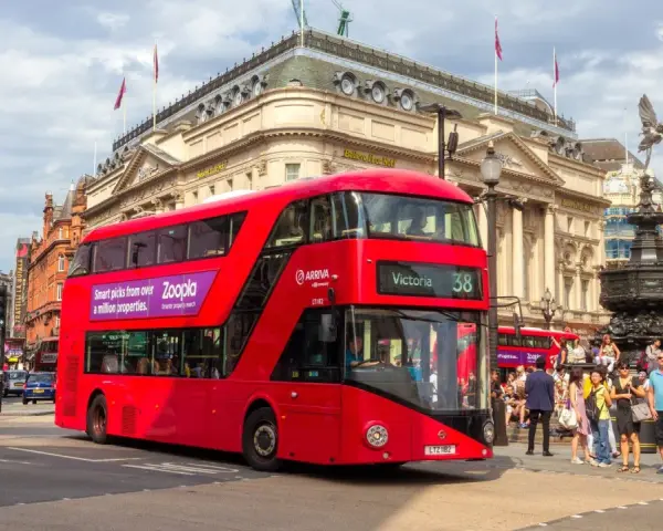 Czerwony piętrowy autobus w Londynie na tle Piccadilly Circus.