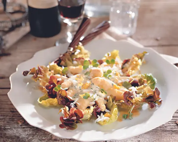 Omas Spargelsalat mit cremigem Dressing, Eiern und Kräutern, serviert auf einem weißen Teller mit Salatblättern.