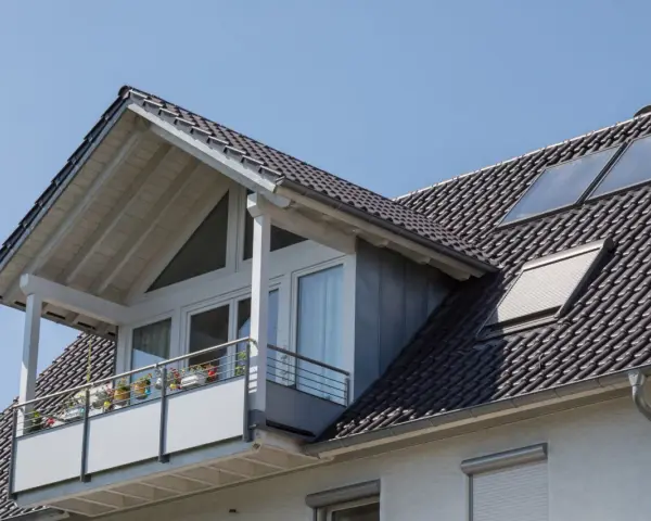 Dachgaube mit Balkon und Solarpaneelen. Informieren Sie sich über Dachgaube Kosten für Ihr Zuhause.