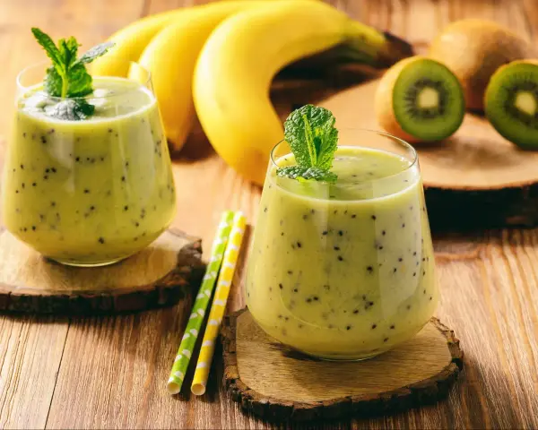 Orzeźwiający koktajl z jogurtem, kiwi i bananem, ozdobiony miętą. Idealny na letnie popołudnie.