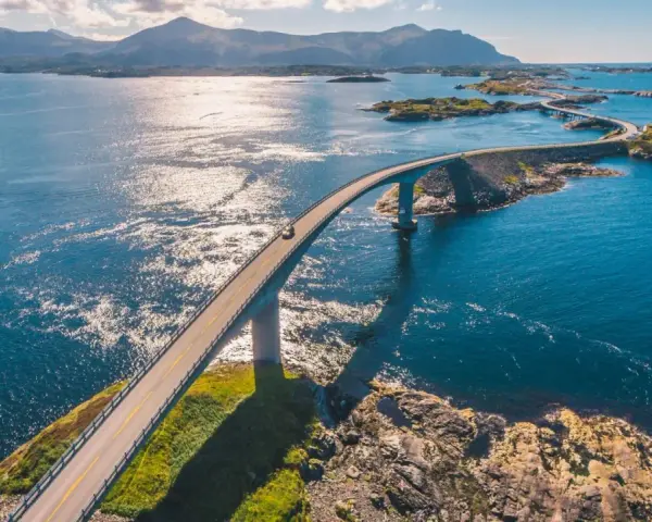 En bil kör över en bro i Norge, en del av den fantastiska Atlantvägen. En dröm att åka till Norge och uppleva detta!