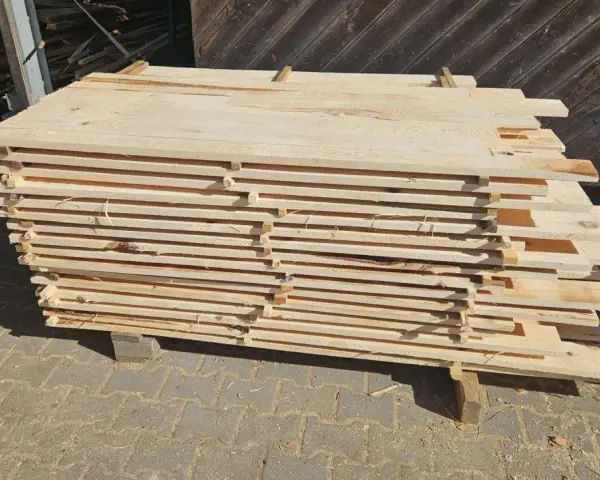 Stos desek z drewna sosnowego, gotowych do sprzedaży. Sprawdź aktualną drewno sosnowe cena za m3.