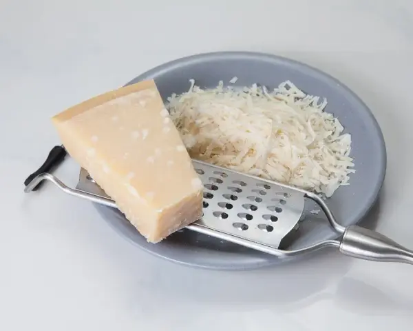 Kawałek sera i tarka na talerzu. Szukasz, czym zastąpić parmezan? Oto inspiracja!