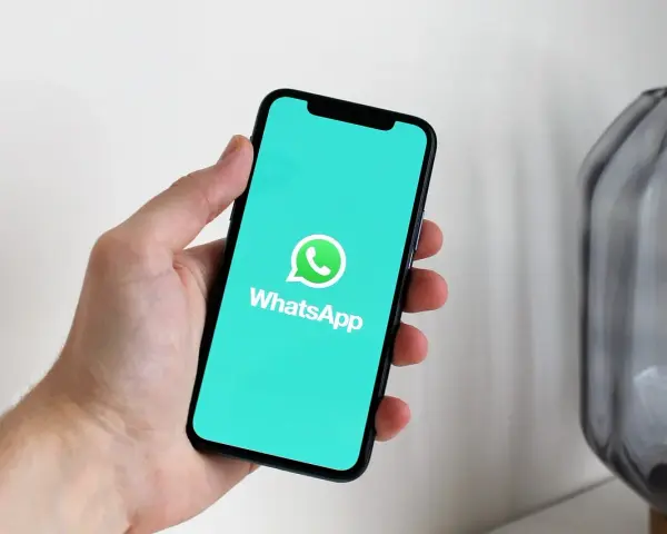 Dłoń trzyma smartfon z logo WhatsApp. Idealne narzędzie do komunikacji, gdy masz internet za granicą.