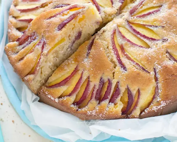 Torta di pesche velocissima, soffice e profumata, con fette di pesca disposte a raggiera sulla superficie dorata.