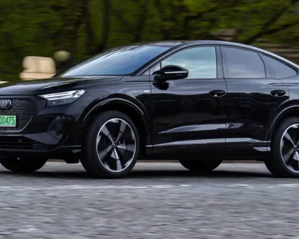 Czarny Audi Q4 e-tron w ruchu. Sprawdź, jaki jest jego zasięg na jednym ładowaniu.