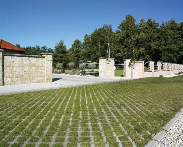 Płyta ażurowa 8 ile na palecie, idealna na podjazd. Zielona trawa rośnie w otworach, tworząc estetyczny wygląd.