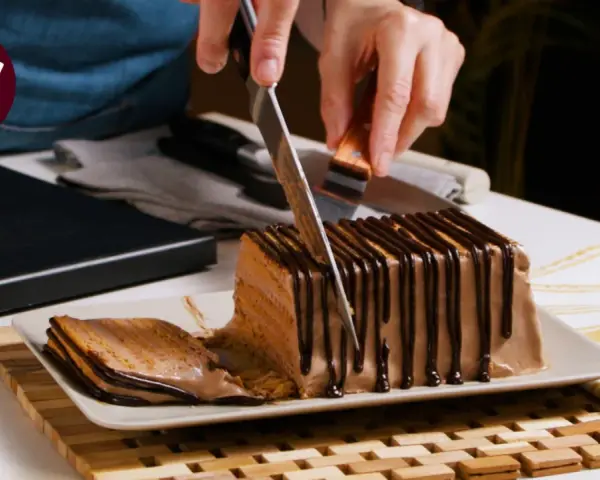 Cortando una porción de la deliciosa tarta de queso casera de la abuela, cubierta con chocolate.