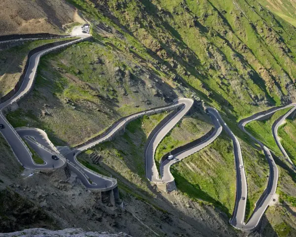 Strada tortuosa che sale verso il passo più alto d'Europa, con tornanti stretti e panorami mozzafiato.