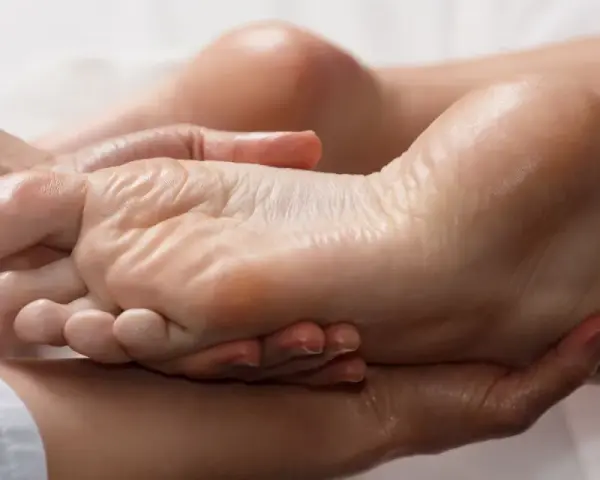 Mains expertes prodiguant un massage relaxant pour une manucure pied parfaite, hydratant et apaisant.