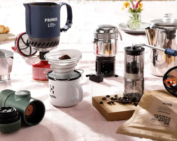 Perfekt für Kaffee kochen Camping: Mokkakanne, Filterkaffee-Set, French Press und Kaffeemühle auf einer Decke.