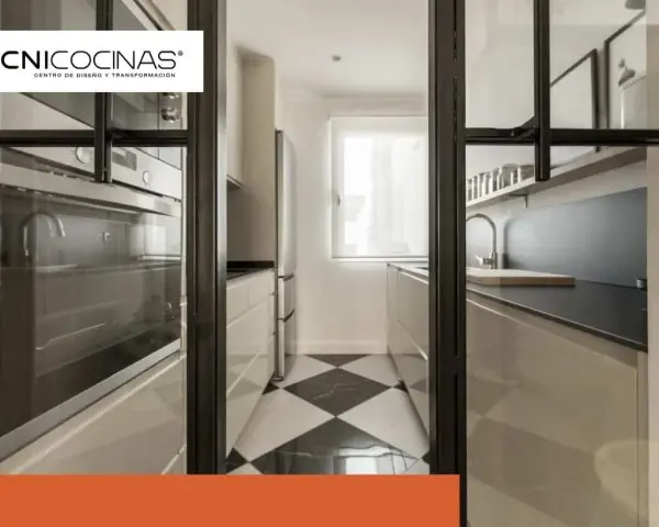 Cocina semiabierta cristal con suelo de damero, electrodomésticos integrados y encimera moderna.