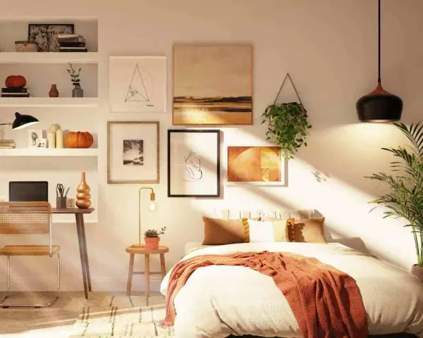 Acogedor dormitorio con cama sin cabecero, escritorio y estanterías llenas de arte y objetos decorativos.