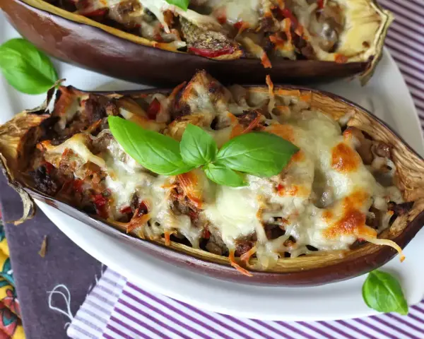 Melanzane ripiene al forno velocissime, dorate e filanti, guarnite con basilico fresco. Un piatto invitante e facile da preparare.