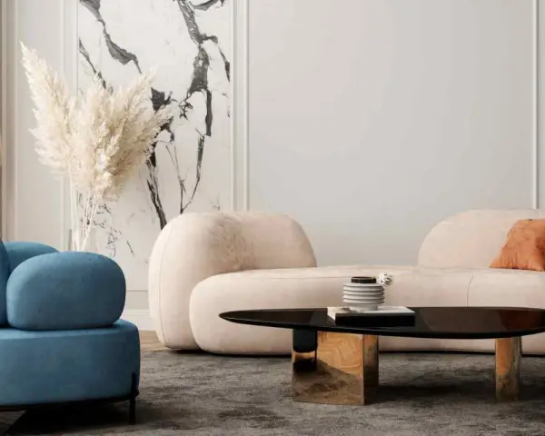Un divano beige dalle forme morbide crea un'atmosfera accogliente, con abbinamenti di cuscini in terracotta e blu.