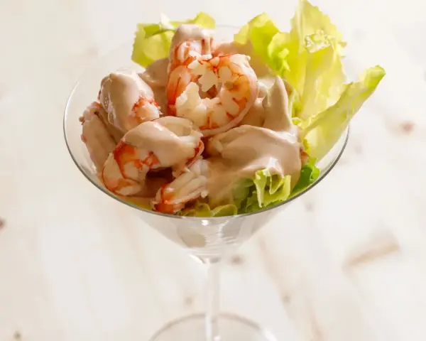 Gamberetti in salsa rosa, un antipasto fresco e gustoso servito in una coppa, con foglie di lattuga croccante.
