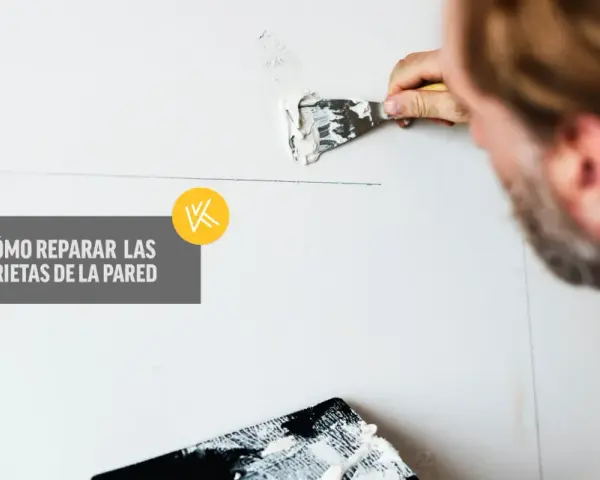 Hombre repara grietas en pared con aguaplast. Aprende por qué se agrieta el aguaplast y cómo solucionarlo.