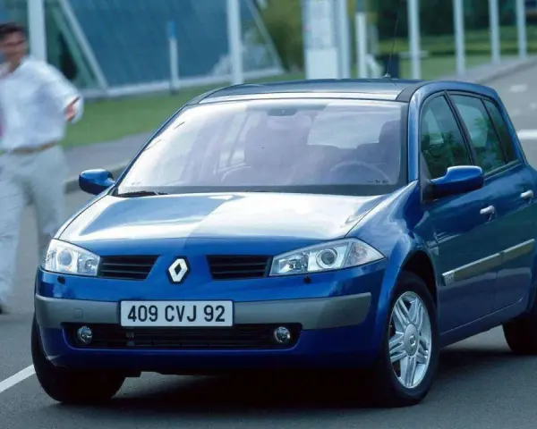 Niebieski Renault Megane 2 na drodze, z parą ludzi w tle.