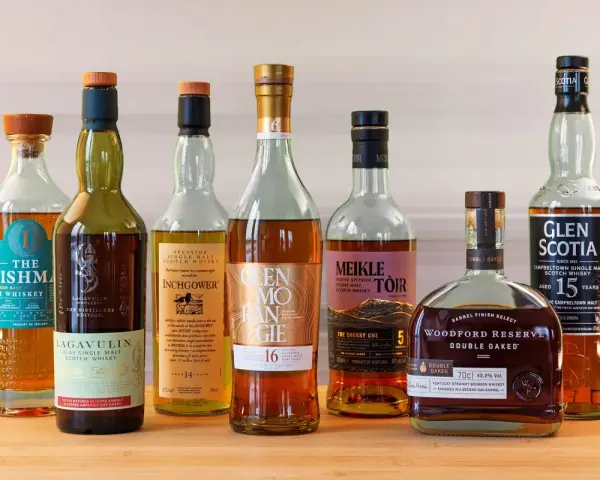 Eine Auswahl von sieben Flaschen, darunter Irish Whiskey und Scotch, die zu den top 10 besten Whisky zählen könnten.