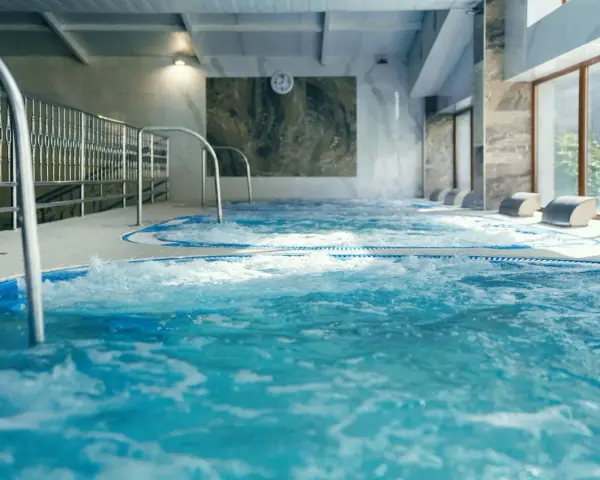 Relaks w hotelu z basenem w Białymstoku. Bąbelki unoszą się w wodzie jacuzzi, zapraszając do odpoczynku.