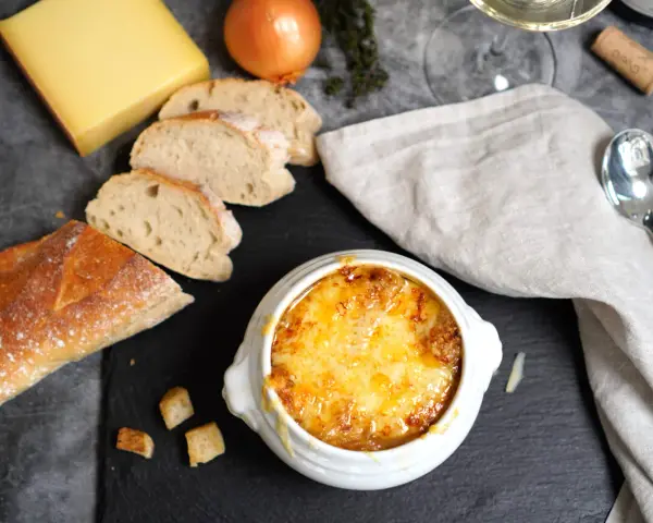 Herzhaftes Zwiebelsuppen-Rezept: goldbraun überbackene Suppe mit Käse, Baguette und Zwiebeln.