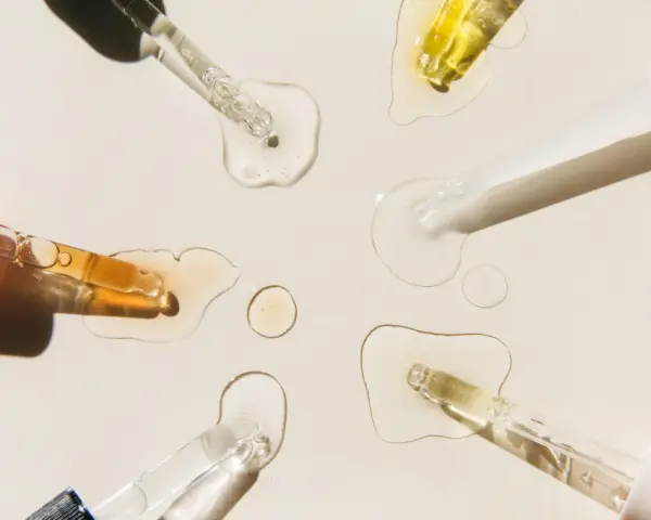 Krople serum i pipetki na jasnym tle.