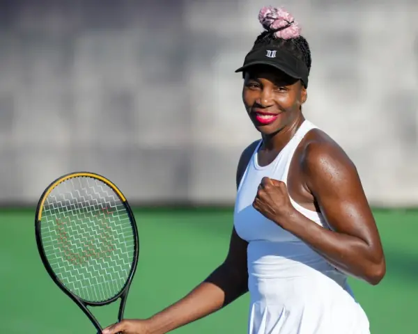 Venus Williams, con su estatura imponente, celebra un punto en la cancha de tenis.
