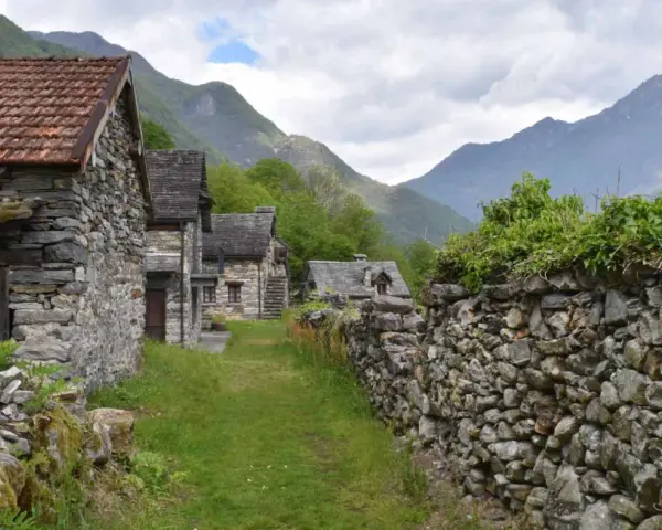 Steindörfer im Valle Maggia, umgeben von grünen Bergen und bewachsenen Mauern.