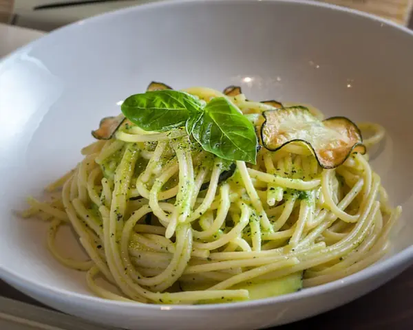 Spaghetti alla Nerano con calabacín y albahaca en un cuenco blanco.