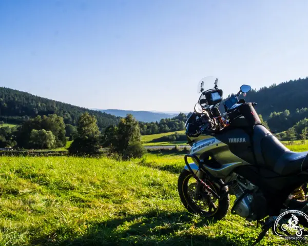 Motocykl Yamaha zaparkowany na łące, w tle malownicze wzgórza Bieszczad. Idealne miejsce na przejażdżkę pętlą bieszczadzką.