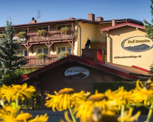 Hotel Pod Szrenicą w Szklarskiej Porębie, otoczony zielenią i kwitnącymi kwiatami, zaprasza na wypoczynek.