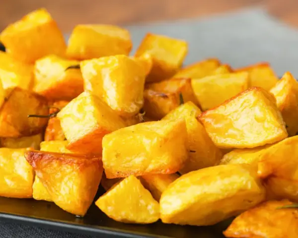 Un mucchio invitante di patate al forno croccanti, dorate e profumate, pronte per essere gustate.