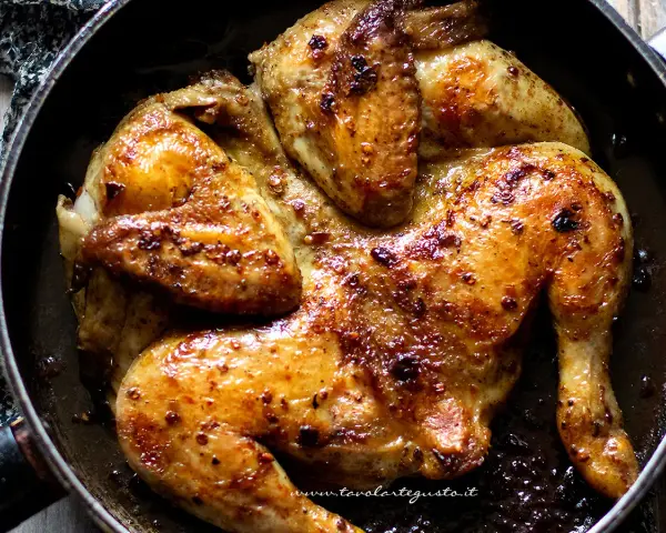 Pollo alla diavola dorato e succulento, cotto in padella con spezie piccanti.
