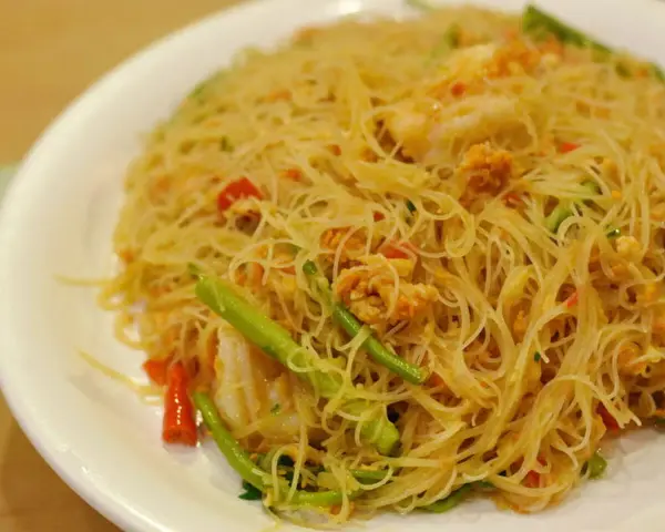 Pyszne danie z cienkim makaronem, przypominającym vermicelli czy capellini, z kawałkami krewetek i zielonych warzyw.