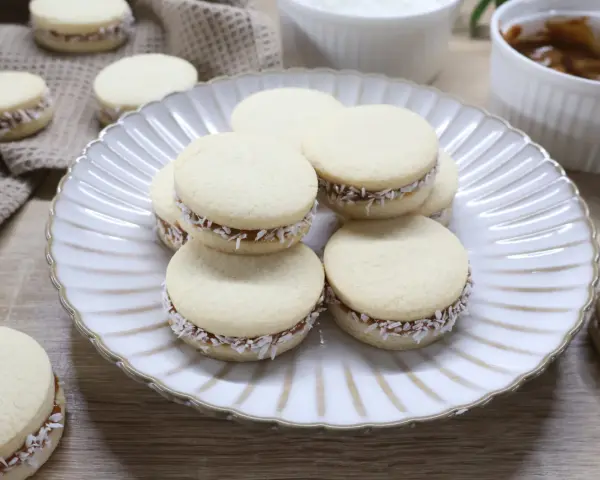 Pyszne domowe alfajores z kajmakiem i wiórkami kokosowymi. Idealne na deser, zgodnie z przepisem na alfajores.