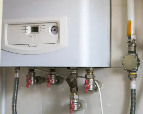Caldaia a gas con pannello di controllo e tubazioni. Il tubo scarico fumi scaldabagno a gas normativa è essenziale per la sicurezza.
