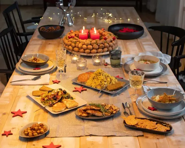 Festlich gedeckter Tisch mit leckerem Essen, bereit für das weihnachtsessen einen tag vorher vorbereiten. Kerzen brennen, Nüsse und Tannenzapfen schmücken.