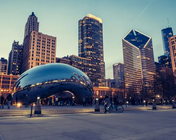 Reflections of the Chicago skyline shimmer on the iconic Cloud Gate sculpture. A perfect snapshot of Chicago in a day, with people enjoying the evening.