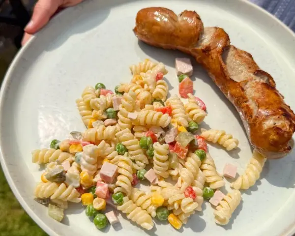 Ein herzhafter Nudelsalat mit Erbsen, Mais und Schinken, perfekt als Beilage zu einer gegrillten Wurst. Was passt zu Nudelsalat? Diese Kombination!