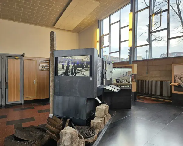 Ausstellung im "Palace of Tears" Berlin: Ein Stein, ein Bildschirm mit historischem Bild, und Ausstellungsstücke erinnern an die Teilung.