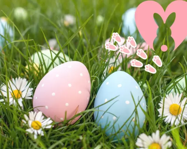 Bunte Ostereier im Gras, ein Herz mit Hase und Pfotenabdrücken. Ein fröhlicher Ostersonntag, der an die Auferstehung erinnert.