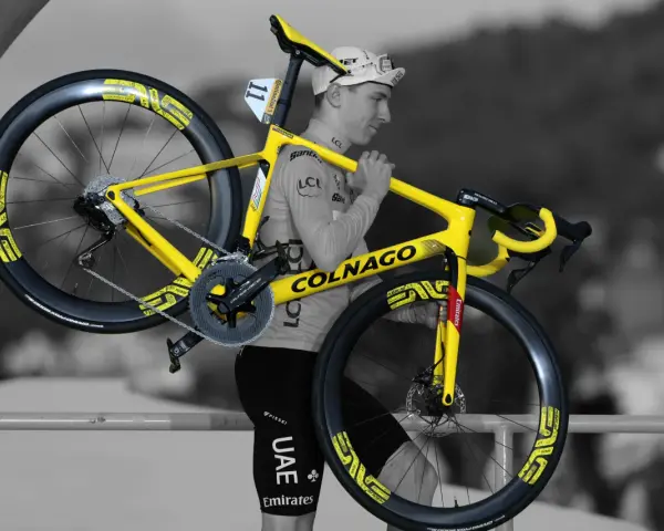 A cyclist carries his bright yellow Colnago bike, ready for Tour de France training.