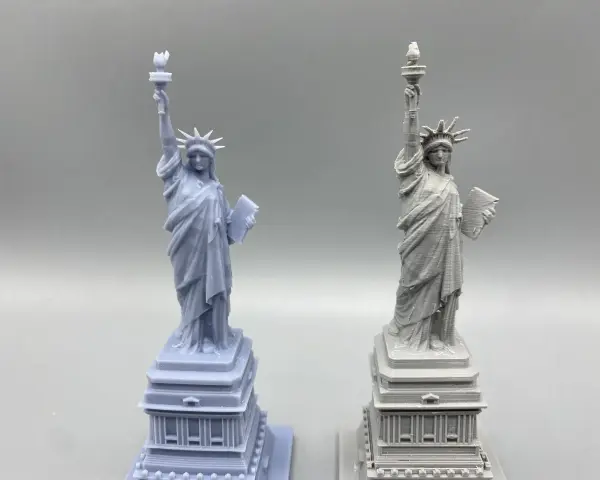 Two Statue of Liberty models: one smooth, likely resin vs. filament 3d printer with visible layer lines.