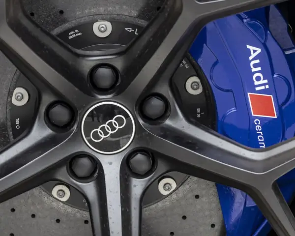 Primo piano di un cerchio Audi RS6 con pinze freno blu e logo Audi.