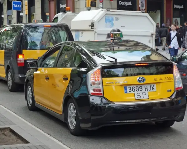 Gelbe Taxis in Barcelona, ein Toyota Prius und ein größeres Taxi XL, warten auf Fahrgäste.