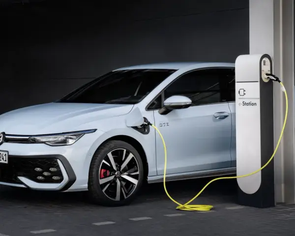 Jasnoniebieski Volkswagen Golf GTE podłączony do stacji ładowania e-Station.
