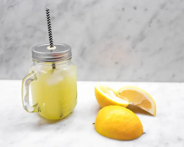 En burk med hemgjord lemonad, is och citronskivor. Perfekt för ett enkelt lemonad recept.
