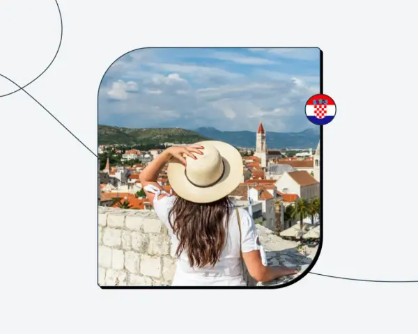 Kobieta w kapeluszu patrzy na chorwackie miasto z muru. Flaga Chorwacji.