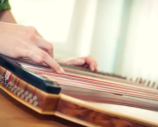 Hände spielen auf einem Hackbrett, das vielleicht das einfachste Instrument ist, um Melodien zu erzeugen.