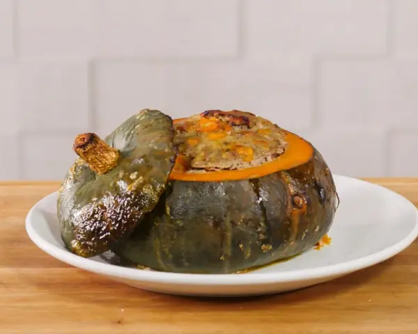 Deliziosa zucca ripiena, con un appetitoso ripieno dorato che fuoriesce dal suo guscio cotto.